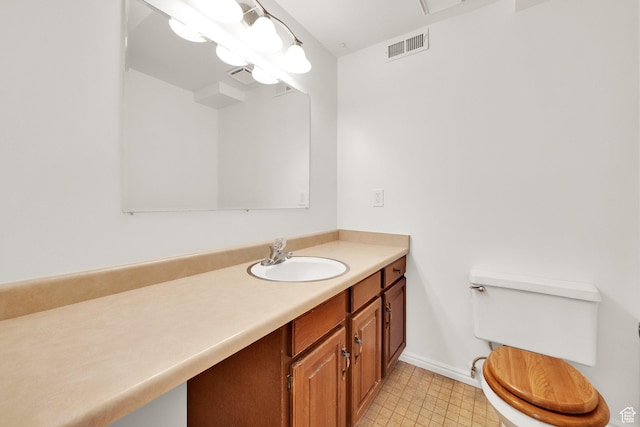 bathroom with visible vents, toilet, vanity, and baseboards