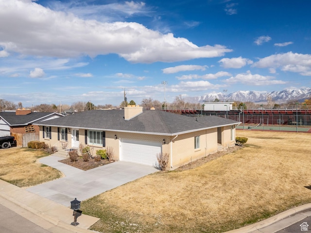 single story home with a garage, a chimney, roof with shingles, and a front lawn