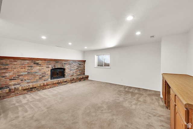 unfurnished living room with recessed lighting, light colored carpet, and a fireplace