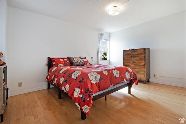 bedroom featuring light wood-style floors and baseboards