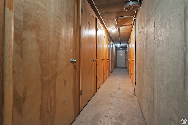 hall featuring unfinished concrete flooring