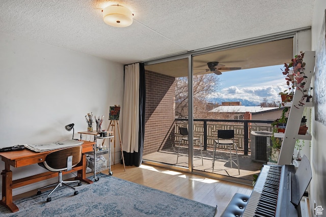 office with ceiling fan, a textured ceiling, wood finished floors, and floor to ceiling windows