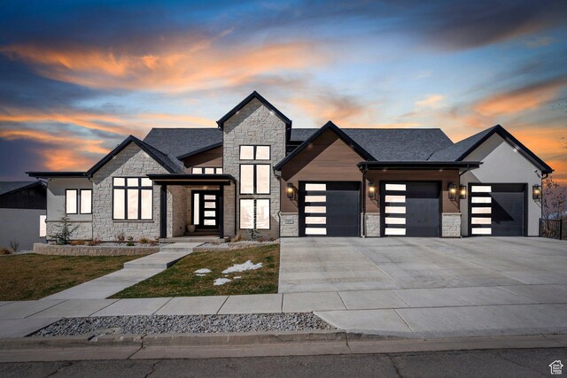 modern home featuring concrete driveway, an attached garage, and stone siding
