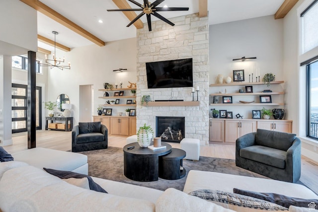 1413 N 1500 E, Provo, UT 84604 - living room featuring beamed ceiling, light wood-style flooring, ceiling fan with notable chandelier, a stone fireplace, and a towering ceiling