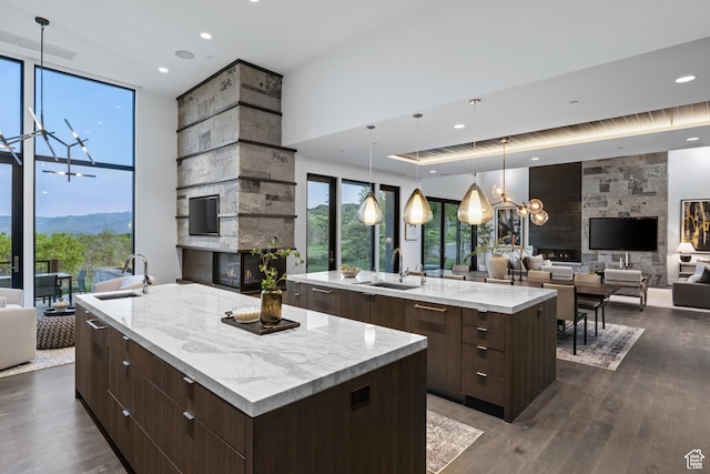 9774 N Red Hawk Trl, Park City, UT 84098 - kitchen with a large island, a chandelier, modern cabinets, a sink, and floor to ceiling windows