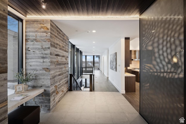 9774 N Red Hawk Trl, Park City, UT 84098 - hallway with a wall of windows, baseboards, recessed lighting, wooden ceiling, and an upstairs landing