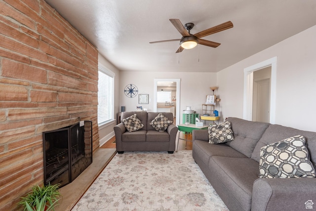 living room with a fireplace and ceiling fan