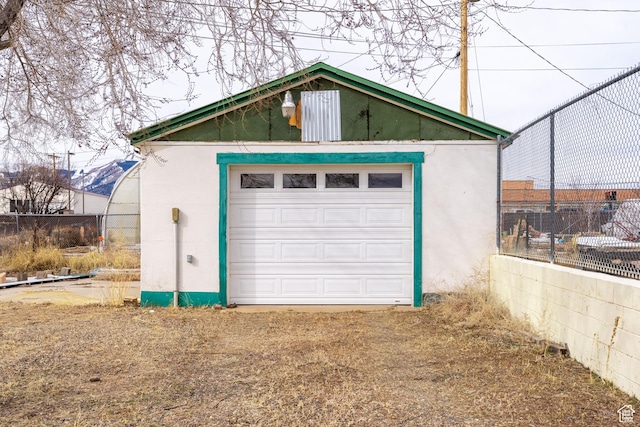 detached garage with fence and driveway