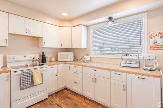 kitchen with white appliances, light wood-style flooring, recessed lighting, light countertops, and white cabinets