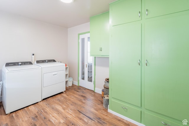 washroom with cabinet space, light wood-style flooring, baseboards, and separate washer and dryer