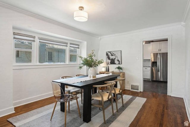 dining room with crown molding, baseboards, dark wood-type flooring, and visible vents