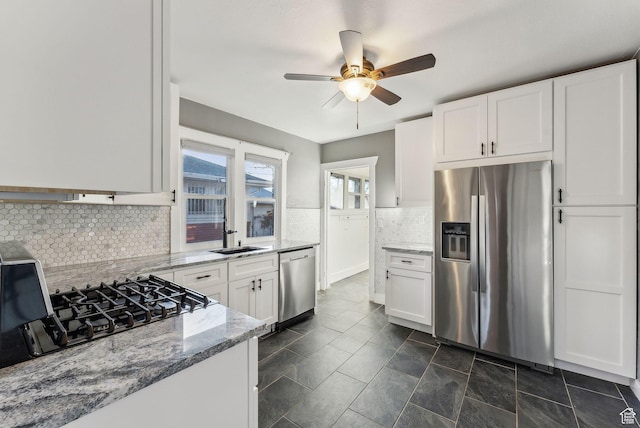 kitchen with ceiling fan, white cabinetry, tasteful backsplash, light stone counters, and stainless steel appliances