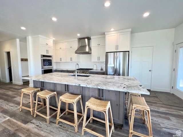 833 W Sunrise Cir, Garden City, UT 84028 - kitchen with a sink, white cabinetry, appliances with stainless steel finishes, wall chimney range hood, and decorative backsplash