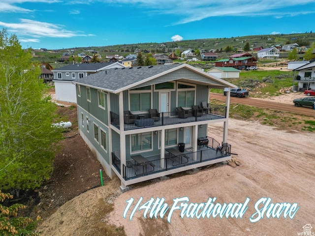 833 W Sunrise Cir, Garden City, UT 84028 - back of house with a balcony, covered porch, a shingled roof, and a residential view