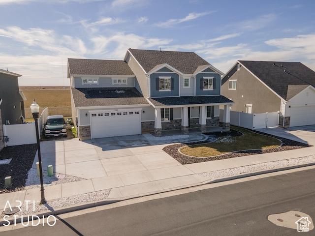 2211 W Parkview Dr, Syracuse, UT 84075 - view of front of property with stone siding, fence, covered porch, concrete driveway, and a garage
