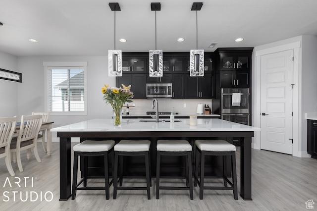 2211 W Parkview Dr, Syracuse, UT 84075 - kitchen with a sink, a breakfast bar, dark cabinets, and stainless steel appliances