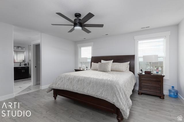 2211 W Parkview Dr, Syracuse, UT 84075 - bedroom with light wood-style flooring, a ceiling fan, baseboards, and connected bathroom