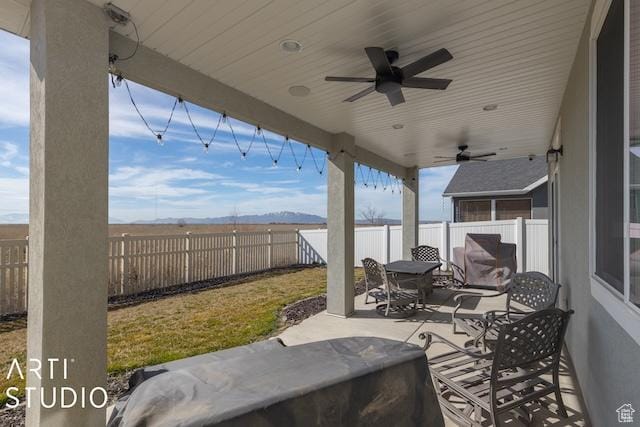 2211 W Parkview Dr, Syracuse, UT 84075 - view of patio / terrace featuring a mountain view, a fenced backyard, a ceiling fan, and outdoor dining space