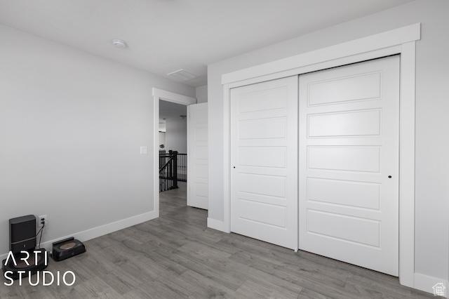 2211 W Parkview Dr, Syracuse, UT 84075 - unfurnished bedroom featuring a closet, baseboards, and wood finished floors
