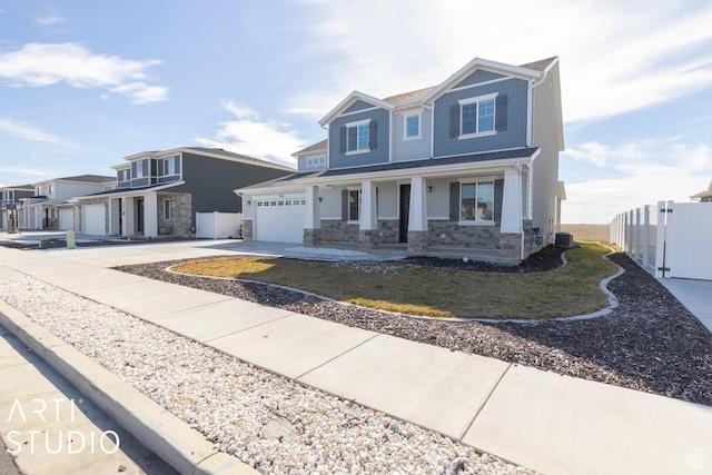 2211 W Parkview Dr, Syracuse, UT 84075 - view of front of property with stone siding, fence, covered porch, and driveway