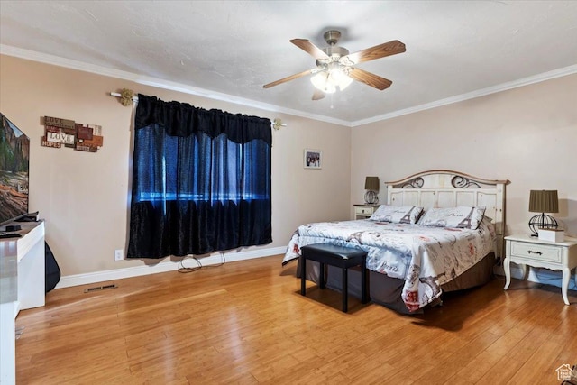 bedroom featuring visible vents, light wood-style flooring, and ornamental molding