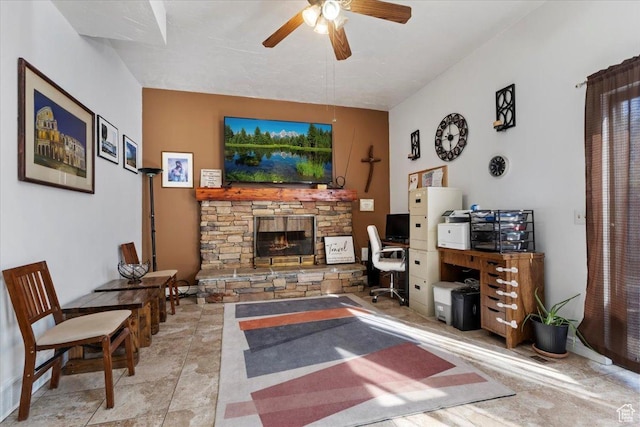 living area featuring a fireplace and a ceiling fan