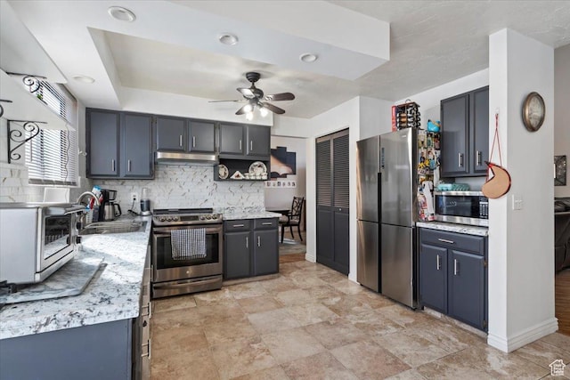 kitchen with a sink, light countertops, ceiling fan, and stainless steel appliances