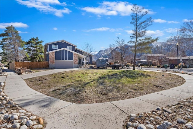 exterior space with concrete driveway, an attached garage, and fence