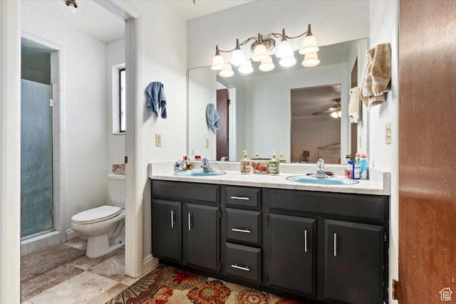 bathroom featuring double vanity, a shower with shower door, toilet, and a sink