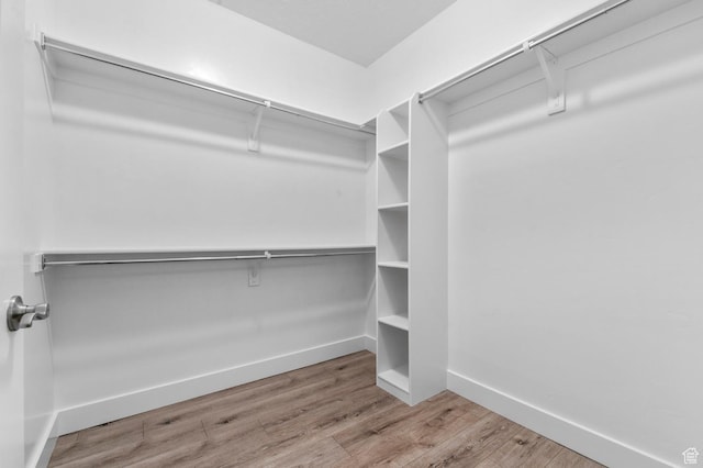 walk in closet with wood finished floors