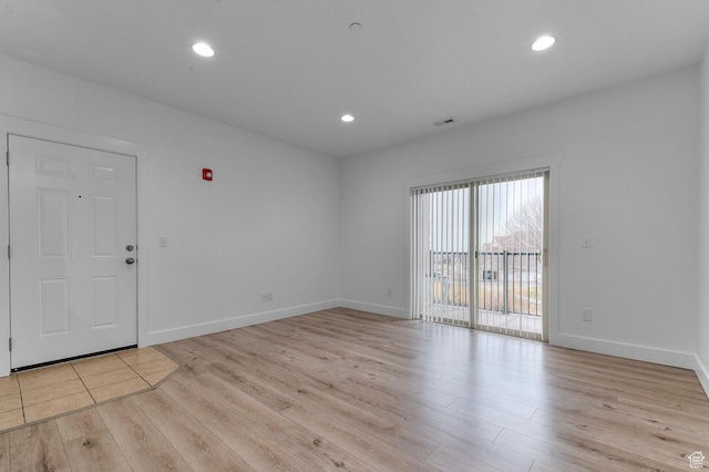 spare room with wood finished floors, baseboards, visible vents, and recessed lighting