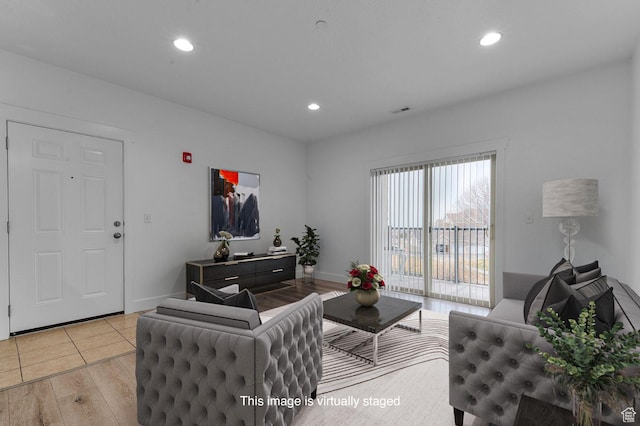 living area with recessed lighting, visible vents, light wood-type flooring, and baseboards