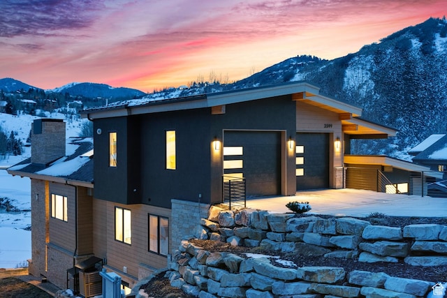 3599 Daybreaker Dr, Park City, UT 84098 - contemporary house with driveway, an attached garage, a mountain view, and a chimney