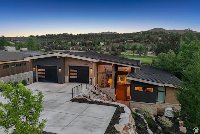 3599 Daybreaker Dr, Park City, UT 84098 - contemporary home featuring stone siding, an attached garage, driveway, and a mountain view