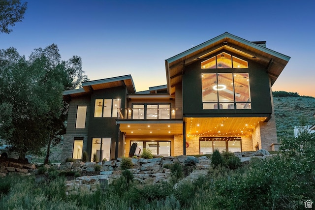 3599 Daybreaker Dr, Park City, UT 84098 - back of property at dusk with a balcony and stone siding