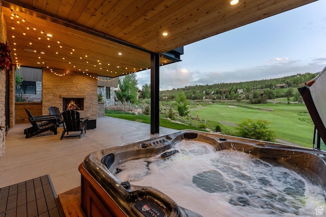 3599 Daybreaker Dr, Park City, UT 84098 - view of patio featuring an outdoor stone fireplace, a hot tub, and golf course view