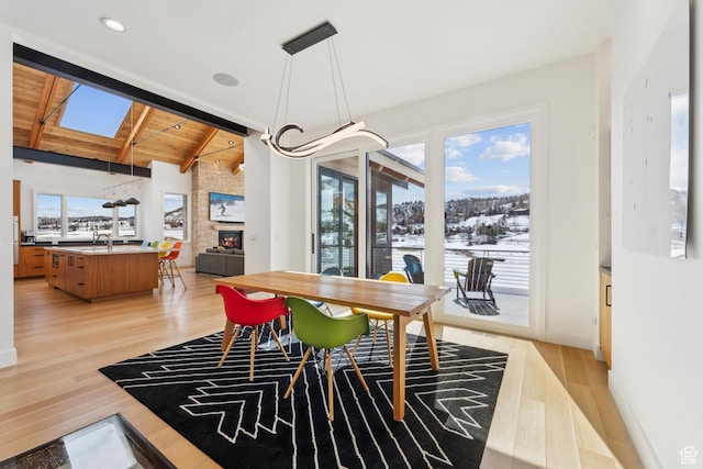3599 Daybreaker Dr, Park City, UT 84098 - dining area featuring wood ceiling, vaulted ceiling with beams, a large fireplace, light wood-type flooring, and recessed lighting