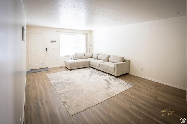 880 E 5700 S, South Ogden, UT 84405 - unfurnished living room featuring baseboards, wood finished floors, and a textured ceiling