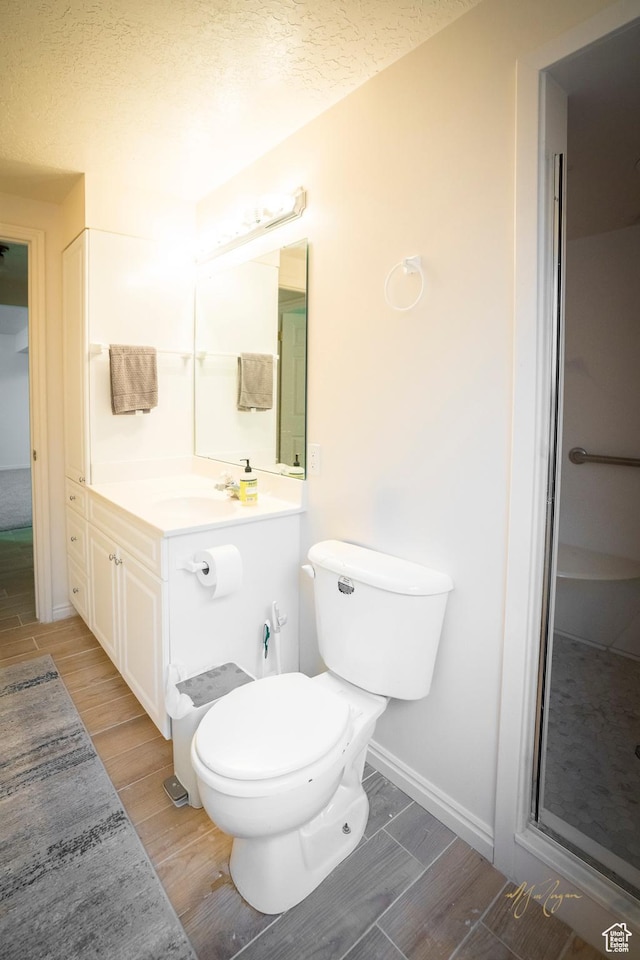 880 E 5700 S, South Ogden, UT 84405 - bathroom featuring wood finish floors, a textured ceiling, vanity, toilet, and baseboards