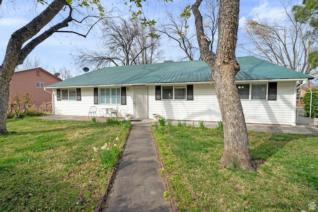 single story home featuring a patio, a front yard, and metal roof