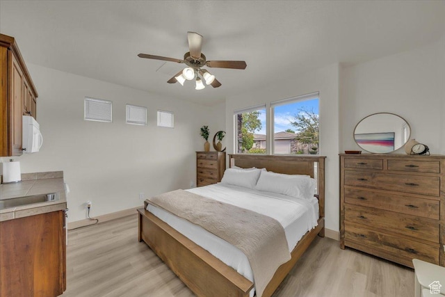 409 N Country Ln Unit 3, St George, UT 84770 - bedroom featuring a ceiling fan, light wood-style floors, and baseboards