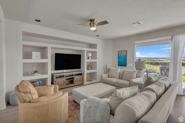 409 N Country Ln Unit 3, St George, UT 84770 - living room featuring visible vents, built in shelves, a textured ceiling, and wood finished floors