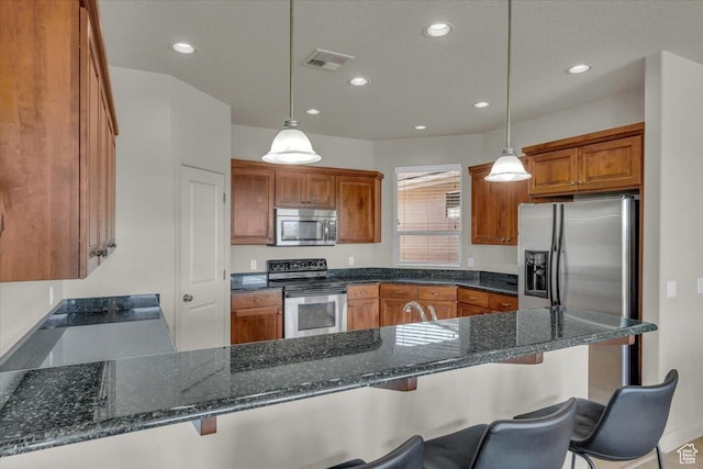 409 N Country Ln Unit 3, St George, UT 84770 - kitchen with visible vents, pendant lighting, stainless steel appliances, a peninsula, and brown cabinetry