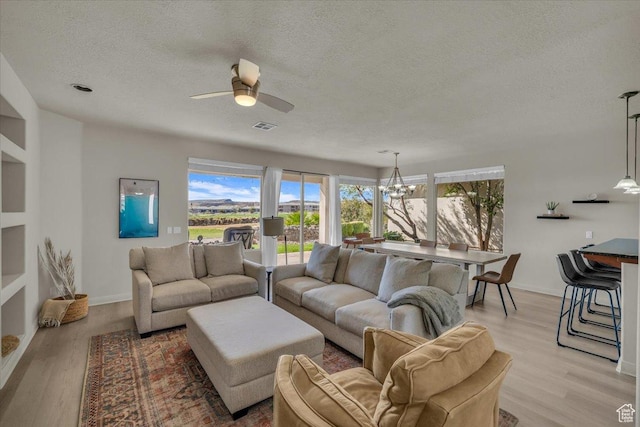 409 N Country Ln Unit 3, St George, UT 84770 - living area featuring light wood finished floors, visible vents, ceiling fan with notable chandelier, and a textured ceiling