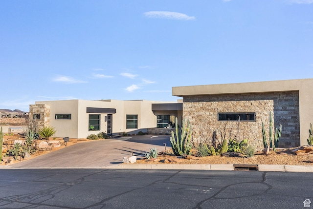view of front of house featuring stone siding and stucco siding