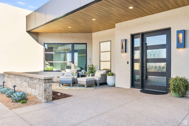 property entrance featuring stucco siding and a patio