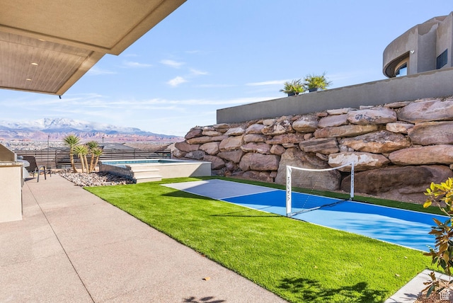 exterior space with an outdoor pool, a mountain view, a patio, and fence