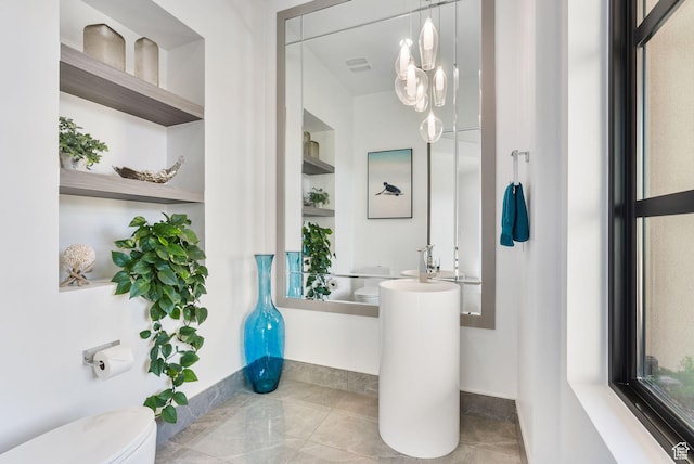 bathroom with baseboards, built in shelves, and toilet