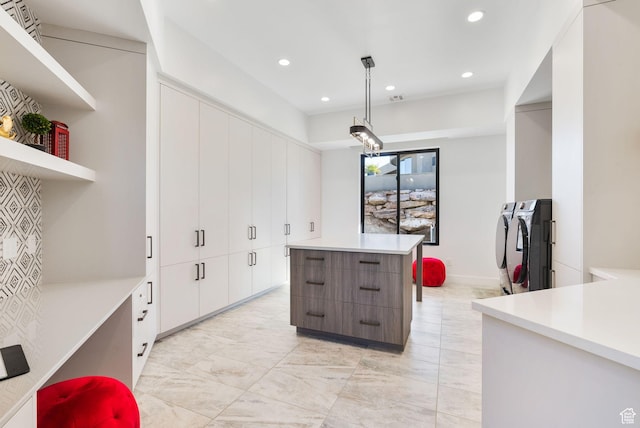 kitchen featuring a kitchen island, light countertops, white cabinetry, modern cabinets, and independent washer and dryer