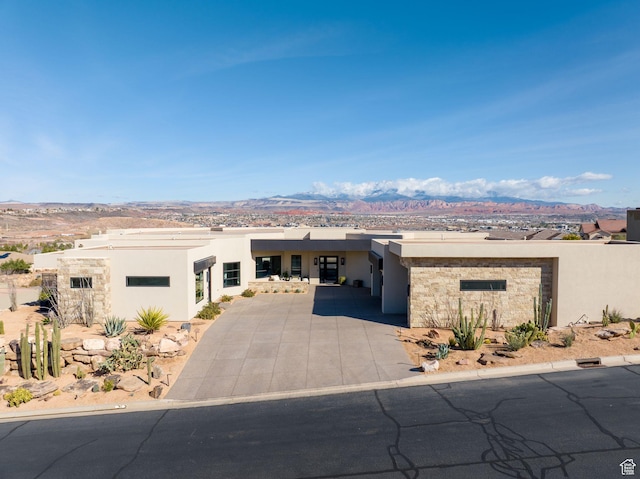 view of front facade featuring a mountain view, driveway, and stucco siding